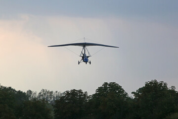 Fototapeta na wymiar Ultralight airplane landing on a farm strip 