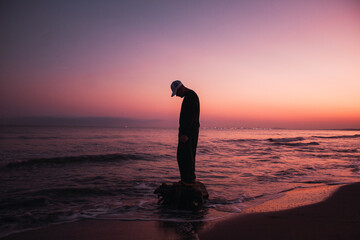 Silueta de hombre posando en la playa al atardecer