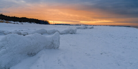 orange sunset on the snowy seashore