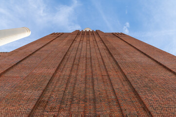 Low angle view at chimneys and brick facade of iconic London landmark Battersea Power Station and surrounding area.