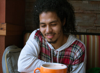 Hombre con pelo largo y barba tomando cafe