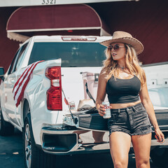 American Patriotic Blonde Girl Drinking Beer with White Pickup Truck and Boots - obrazy, fototapety, plakaty