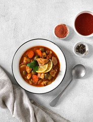 homemade chicken stew pollo guisado with tomatoes souce, onions, carrot, olives and potatoes on plate and rice garnish . vertical top view, copy space