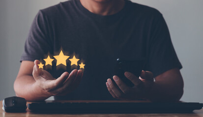 hand of the customer or client holding the stars to complete five stars. giving a five-star rating...