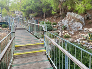 Fototapeta na wymiar Wooden staircase empty with steps up in a rocky mountainous area, an eco-trail tourist in a warm tropical eastern country southern resort