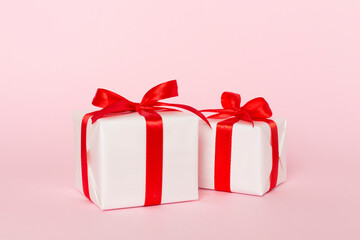Gift box with red ribbon bow on light table