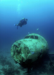 diver and a sunken plane in the crystalline waters of the island of Arube in the caribbean sea