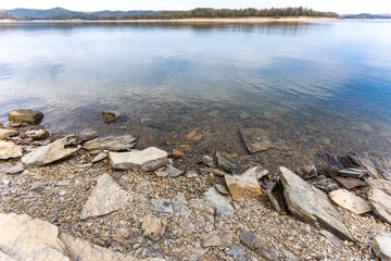 The shoreline of Broken Bow Lake in Oklahoma, USA. Beautiful view of lake and stones on the cost.