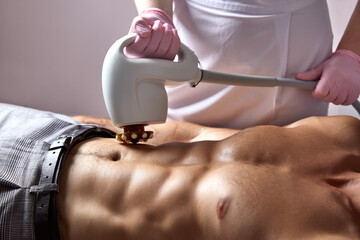 Man receiving fat reductive skin lifting body treatment in cosmetology clinic