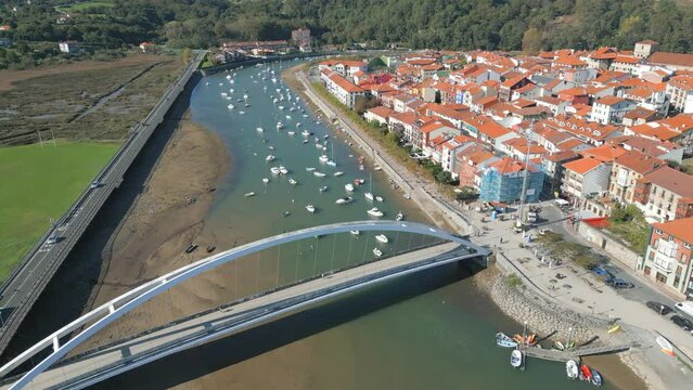 Drone view of the Pasarela De Plentzia Bridge and boats on a river in Spain