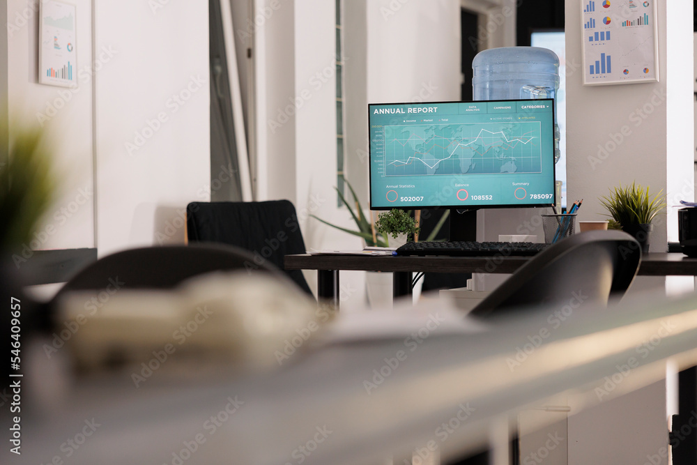 Poster close up of pc with company data analysis on the screen in an empty office before workday starts. co