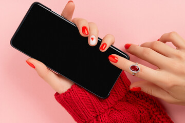 Female hands with manicure and fashion accessories holding a smartphone