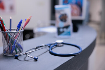 Medical equipment on front desk top with pens and information leaflets in hospital reception....