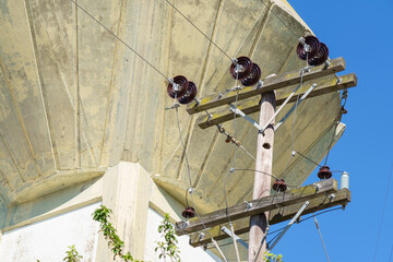Close view of pole for three-phase electricity distribution with cables and insulators