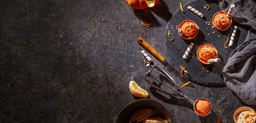 Homemade orange ice cream on a dark background with Ice cream spoon from stainless steel, horizontal banner with space for text, flat lay