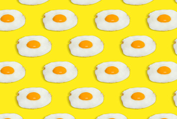 Many tasty fried chicken eggs on yellow background
