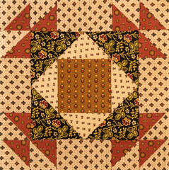 A basic quilt pattern sewn with decorative cotton fabric triangles, rectangles and squares.