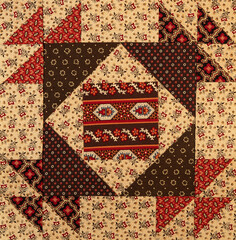 A basic quilt pattern sewn with decorative cotton fabric triangles, rectangles and squares.