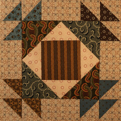 A basic quilt pattern sewn with decorative cotton fabric triangles, rectangles and squares.