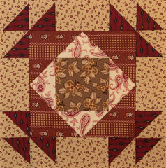 A basic quilt pattern sewn with decorative cotton fabric triangles, rectangles and squares.