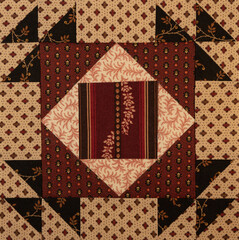 A basic quilt pattern sewn with decorative cotton fabric triangles, rectangles and squares.