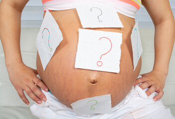 Pregnant woman belly with question mark.