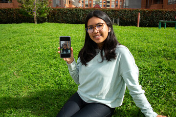 latin woman taking a selfie photo with phone smiling