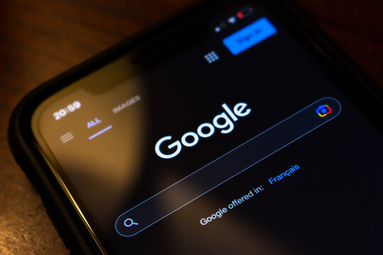 Vancouver, CANADA - Oct 17 2022 : Closeup logo of Google.com website on an iPhone on wooden table. Google LLC is an US multinational technology IT company. Internet SEO search engine concept