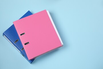Office folders on light blue background, flat lay. Space for text