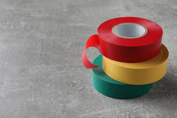 Colorful insulating tapes on light grey table. Space for text