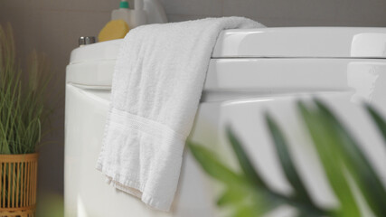 Soft fluffy towel hanging on bathtub indoors