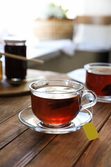 Tea bag in glass cup on wooden table indoors