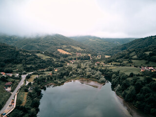 reservoir from a drone near the road that surrounds it and the forest vegetation on a cloudy day, valdemurio reservoir, spain