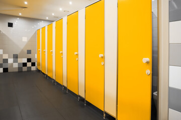 Fototapeta Public toilet interior with bright yellow stalls obraz