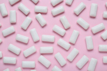 Tasty white chewing gums on pale pink background, flat lay
