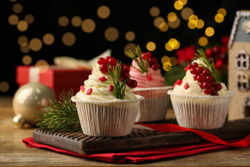 Delicious cupcakes and Christmas decorations on wooden table