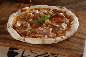 Handmade prosciutto pizza on a wooden table