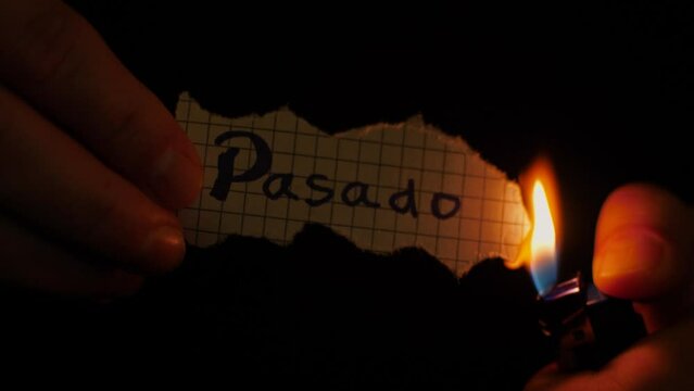 Symbolic burning of piece of paper with the spanish word "pasado" for "past" in english