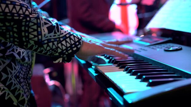man playing piano in a salsa orchestra at a party in a nightclub 