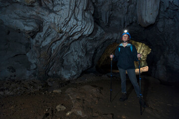 Woman Speleologist Tourist Scouting Situation in a Touristic Karst Cave Underground