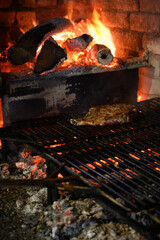 Large beef steak grilled on olive wood firewood grill in small village restaurant in Portugal