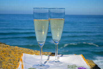Glasses of champagne sparkling wine and view on blue Atlantic ocean, Lisbon area, Portugal