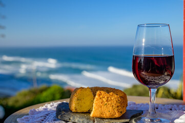 Pairing of Portugeese food and drink, glass of tawny porto wine and codfish croquette pastais de...