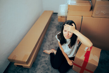 Stressed Woman Feeling Overwhelmed by Relocating in a New Home. Worried millennial girl forgetting...