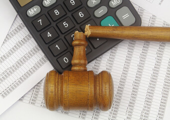 Broken judge gavel and calculator on financial data. Wrong audition concept.