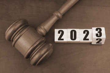 Wooden judge gavel and flipping numbers 2022 and 2023. New laws, rules and court in 2023.