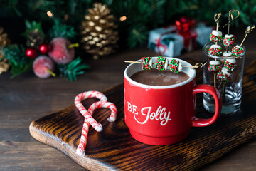 A cup of hot chocolate garnished with chocolate covered marshmallows.