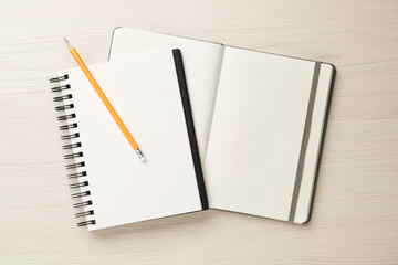Notebooks and pencil on white wooden table, top view