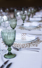
Serving and decoration of the wedding table. Glasses, spoons, forks and white napkins