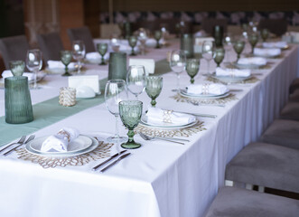 
Serving and decoration of the wedding table. Glasses, spoons, forks and white napkins
